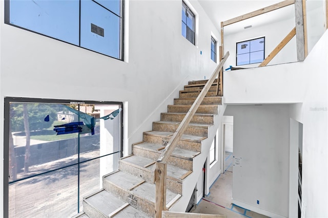 stairway featuring a high ceiling