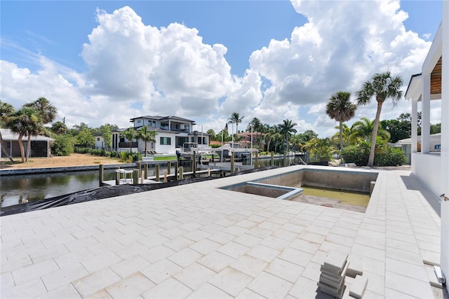 view of patio with a water view and a dock