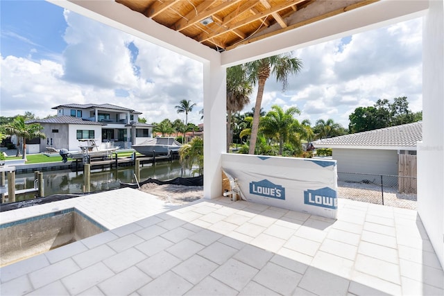 view of patio with a boat dock and a water view