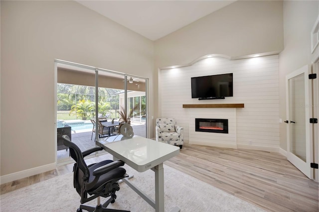 1314 Brambling Ct, Bradenton, FL 34212 - office featuring french doors, wood finished floors, a glass covered fireplace, baseboards, and a high ceiling