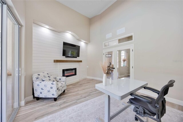 1314 Brambling Ct, Bradenton, FL 34212 - office area with wood finished floors, baseboards, a glass covered fireplace, and french doors