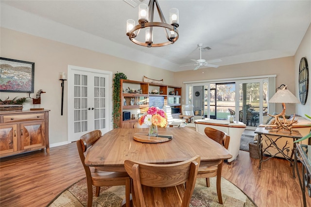 dining space with lofted ceiling, french doors, wood finished floors, and baseboards