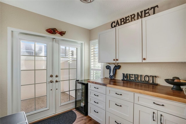 doorway to outside with beverage cooler, french doors, and wood finished floors