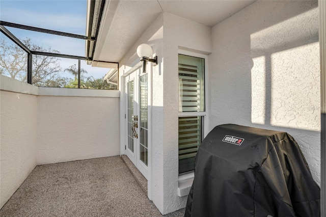 exterior space featuring french doors, glass enclosure, and area for grilling