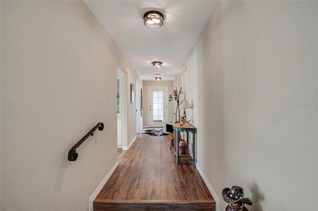 hallway featuring baseboards and wood finished floors