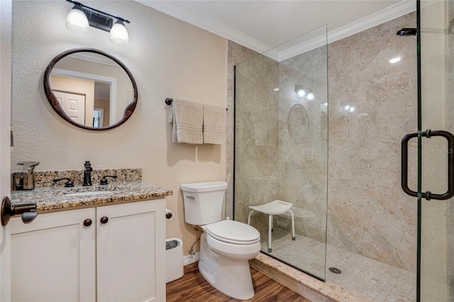 full bath featuring a stall shower, toilet, ornamental molding, wood finished floors, and vanity