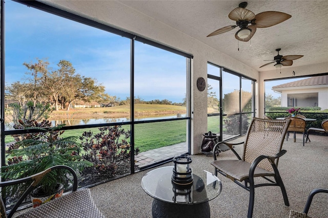 sunroom with a water view and a ceiling fan