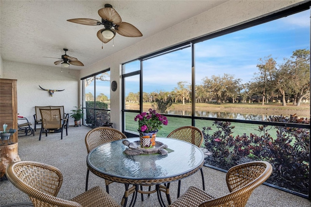 sunroom with a water view and a ceiling fan