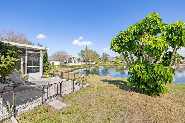 view of yard featuring a water view, a patio, and a sunroom