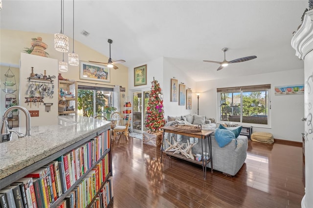 living room with ceiling fan, dark hardwood / wood-style floors, and vaulted ceiling