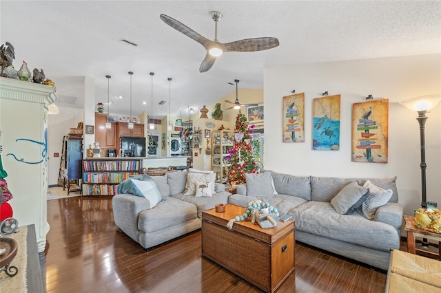 living room with ceiling fan, lofted ceiling, dark hardwood / wood-style flooring, and a textured ceiling