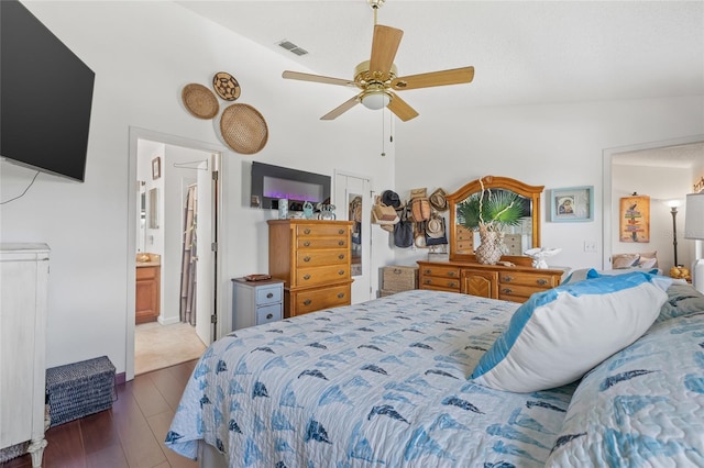 bedroom with ensuite bathroom, dark wood-type flooring, and ceiling fan