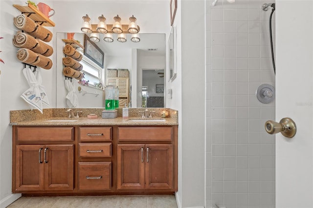 bathroom with vanity and a tile shower