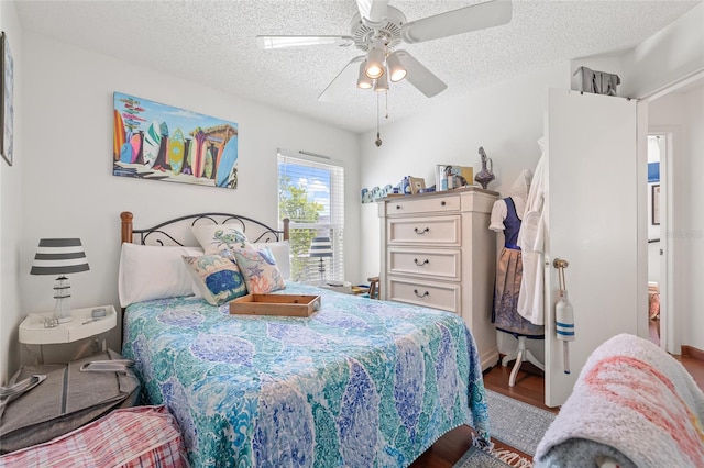 bedroom with hardwood / wood-style flooring, ceiling fan, and a textured ceiling