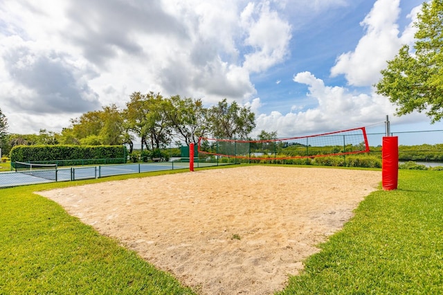 view of property's community with a lawn and volleyball court