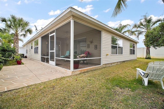 back of property featuring a patio, a sunroom, and a lawn