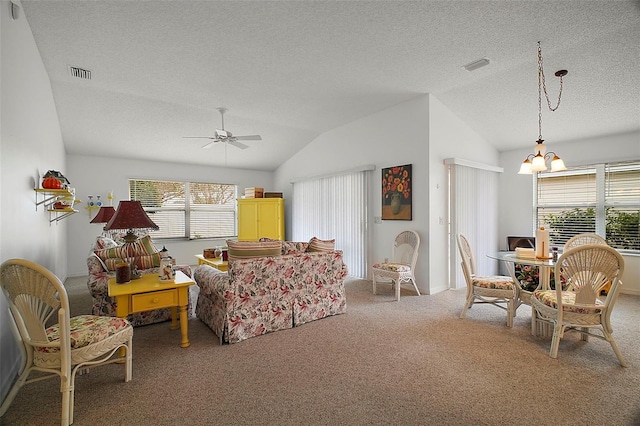 carpeted living room with lofted ceiling, ceiling fan with notable chandelier, and a textured ceiling