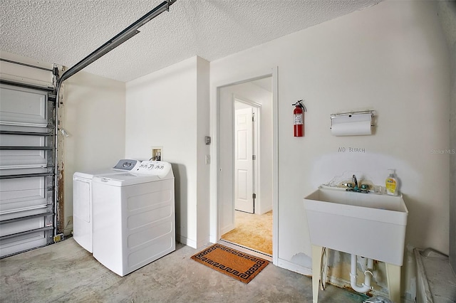 clothes washing area featuring a textured ceiling and washing machine and clothes dryer