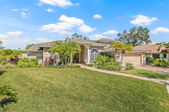 mediterranean / spanish-style home with a garage and a front lawn