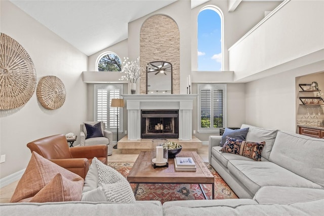 living room featuring high vaulted ceiling, a large fireplace, and ceiling fan