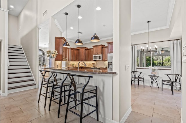 kitchen featuring pendant lighting, a breakfast bar, kitchen peninsula, and appliances with stainless steel finishes