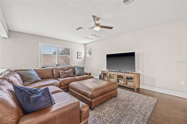 living room with ceiling fan, dark hardwood / wood-style flooring, and a textured ceiling