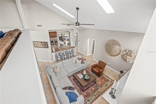 living room featuring ceiling fan, a skylight, and high vaulted ceiling