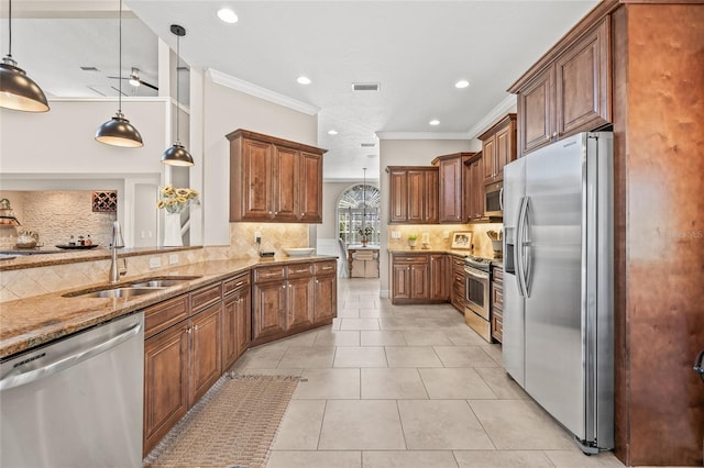 kitchen featuring appliances with stainless steel finishes, sink, light tile patterned floors, and decorative light fixtures