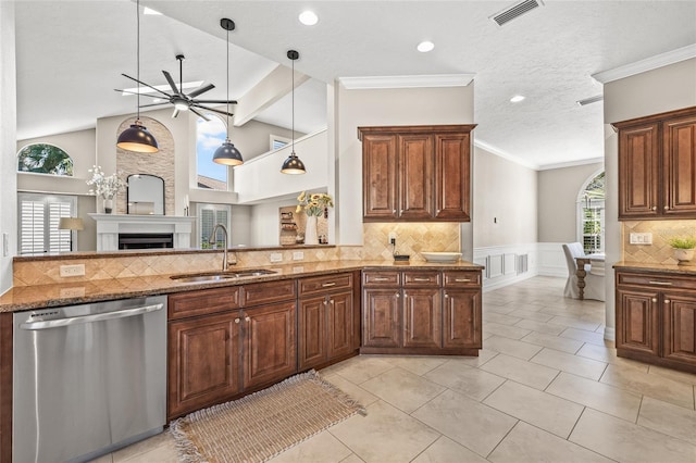 kitchen with sink, dishwasher, dark stone countertops, decorative light fixtures, and kitchen peninsula