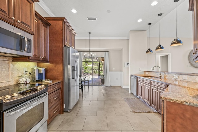 kitchen featuring sink, hanging light fixtures, ornamental molding, stainless steel appliances, and light stone countertops