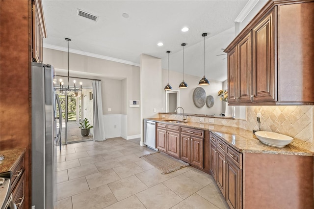 kitchen with pendant lighting, appliances with stainless steel finishes, sink, and decorative backsplash