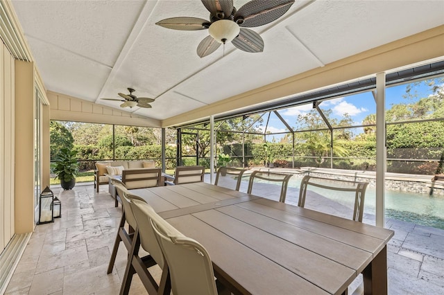 sunroom / solarium with vaulted ceiling, a healthy amount of sunlight, and ceiling fan