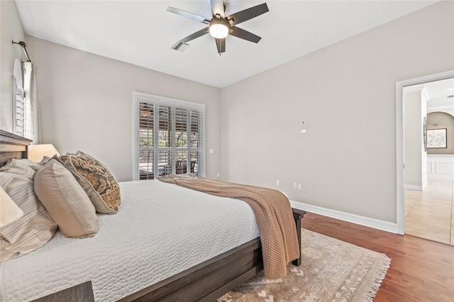 bedroom featuring access to exterior, wood-type flooring, and ceiling fan