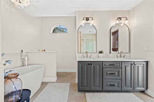 bathroom featuring tile patterned floors, vanity, and a washtub