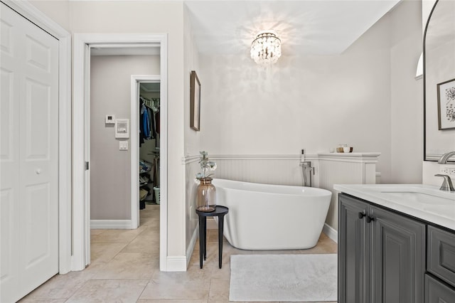 bathroom with vanity, a notable chandelier, tile patterned flooring, and a tub