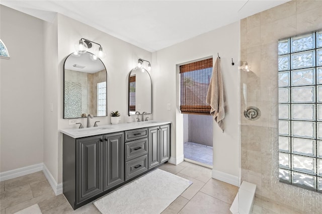 bathroom with vanity, tiled shower, and tile patterned floors