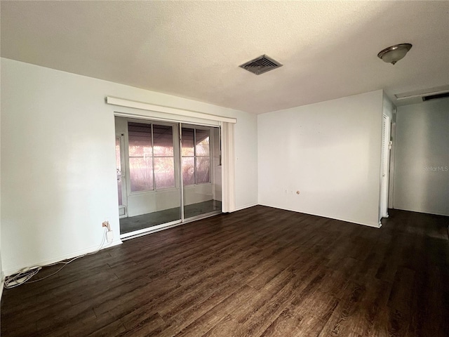 empty room featuring dark hardwood / wood-style floors and a textured ceiling