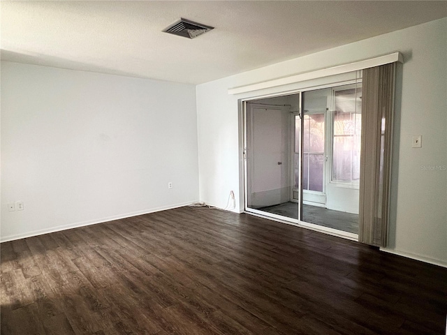 unfurnished room with dark hardwood / wood-style flooring