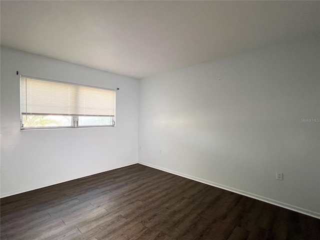 unfurnished room featuring dark wood-type flooring