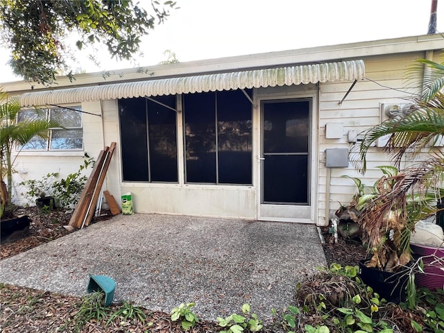 view of exterior entry with a patio