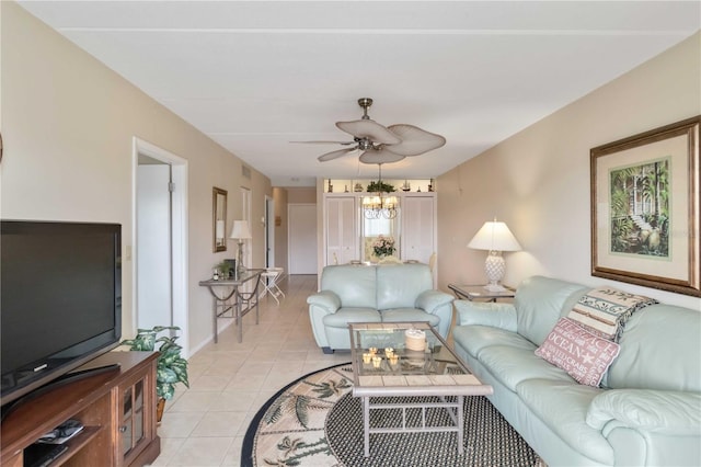 tiled living room with ceiling fan with notable chandelier