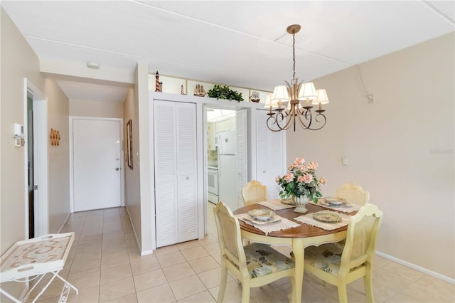 tiled dining room with an inviting chandelier