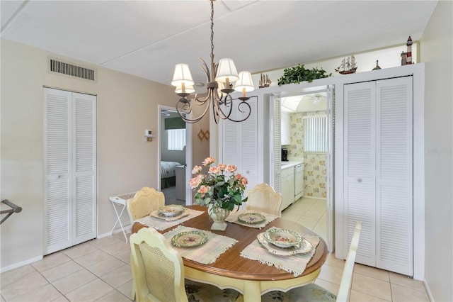 tiled dining room featuring a notable chandelier