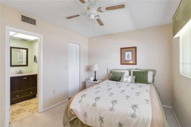 carpeted bedroom with sink, ensuite bath, a closet, and ceiling fan