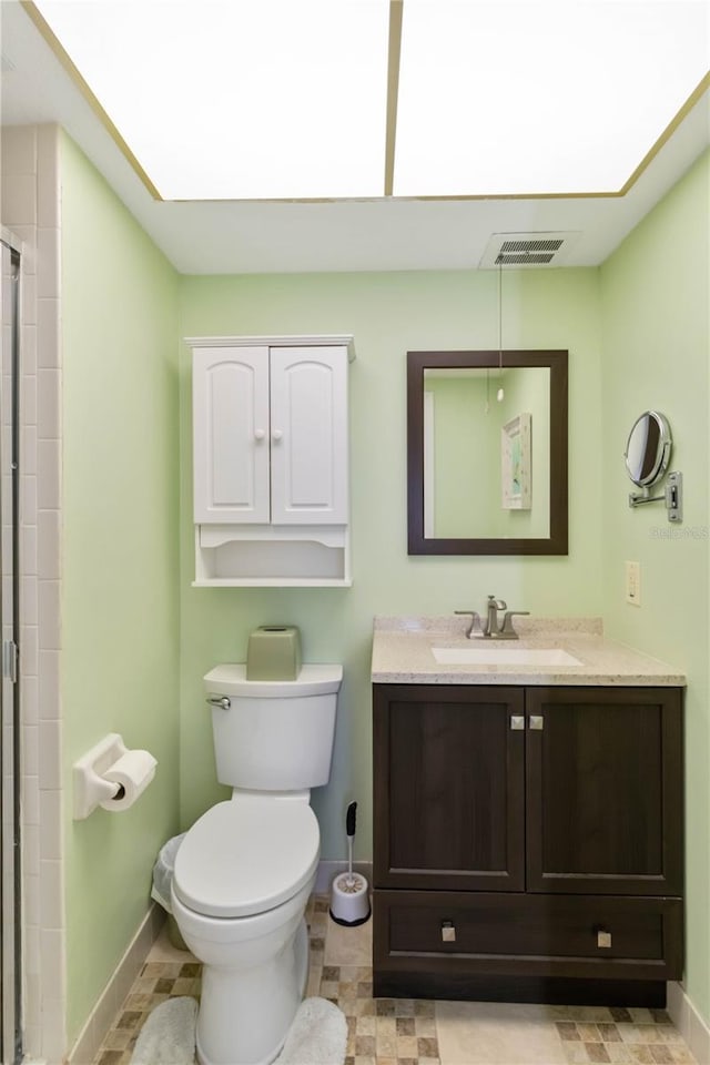 bathroom with vanity, a shower with shower door, and toilet