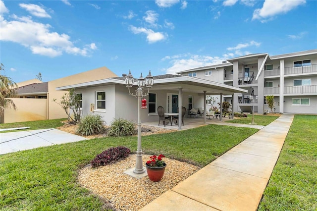 rear view of property with a lawn and a patio