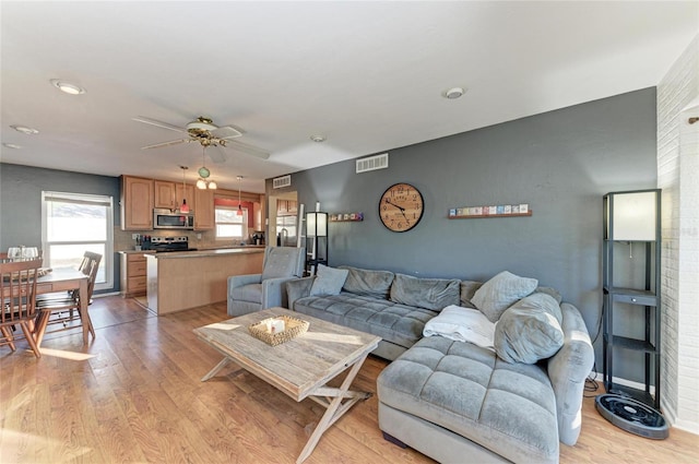 living room with ceiling fan and light hardwood / wood-style flooring