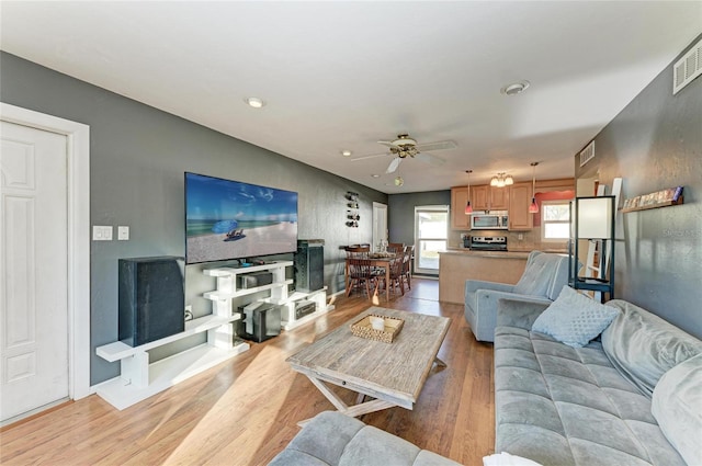 living room with ceiling fan and light wood-type flooring