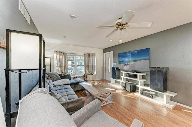 living room featuring wood-type flooring and ceiling fan