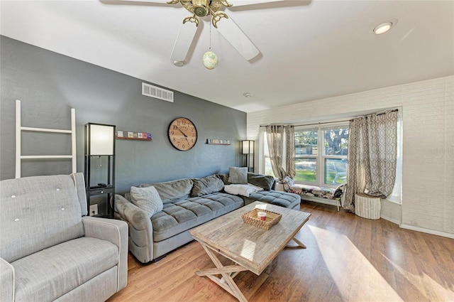 living room with wood-type flooring and ceiling fan